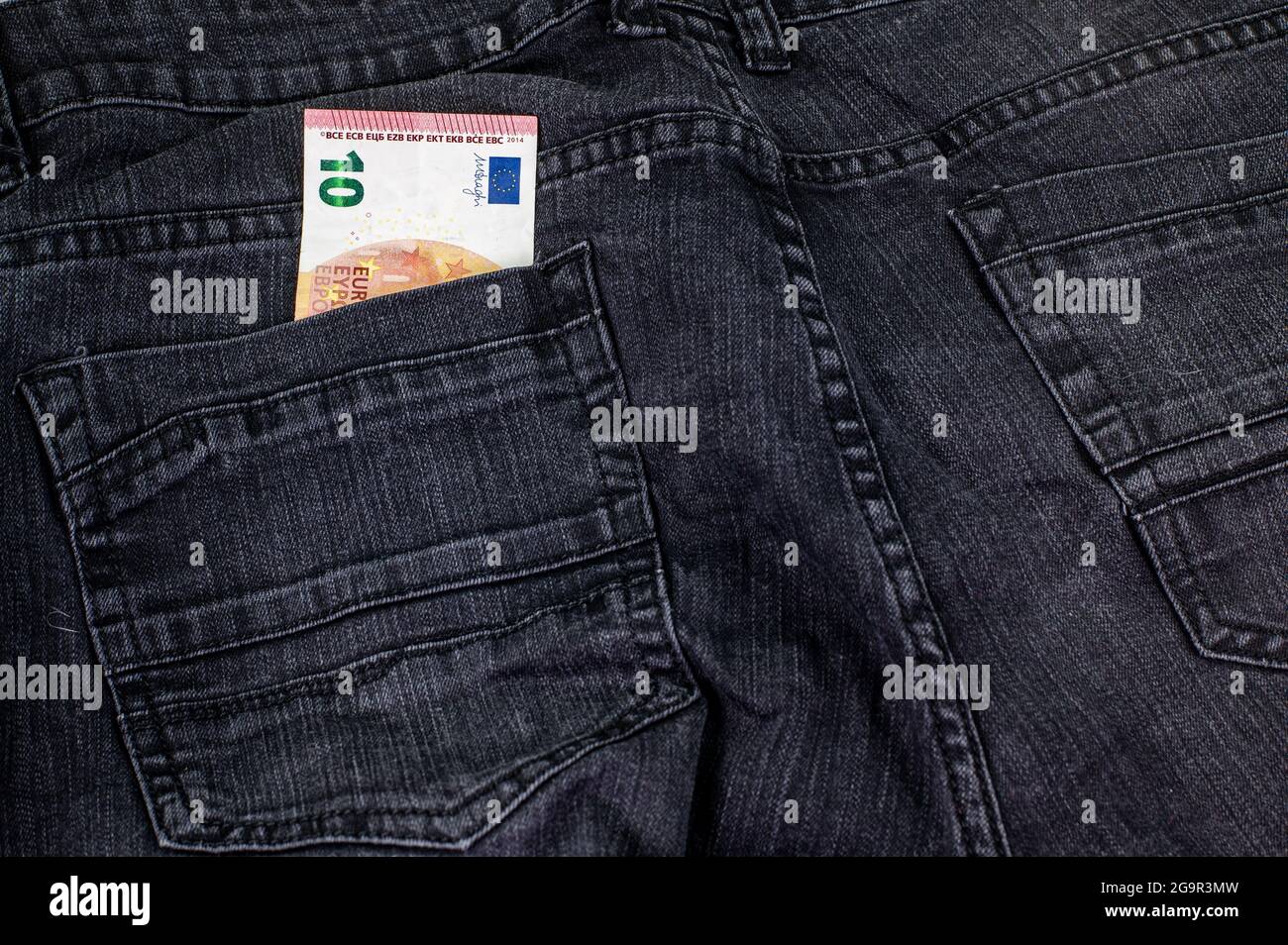 10 Euro, die aus der Tasche schwarzer Jeans kommen Stockfoto