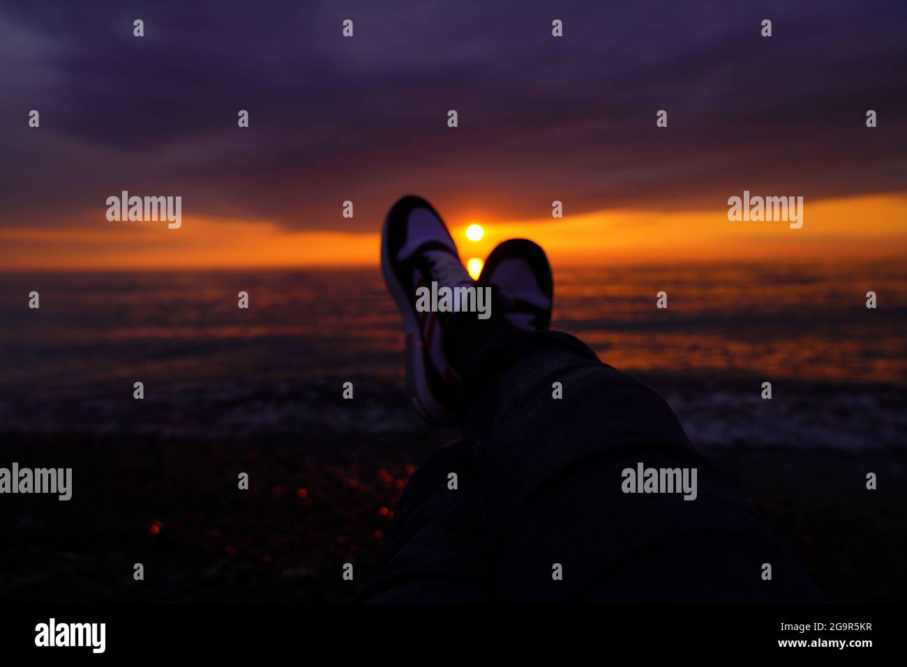 Sneakers auf dem Hintergrund eines schönen Sonnenuntergangs Stockfoto