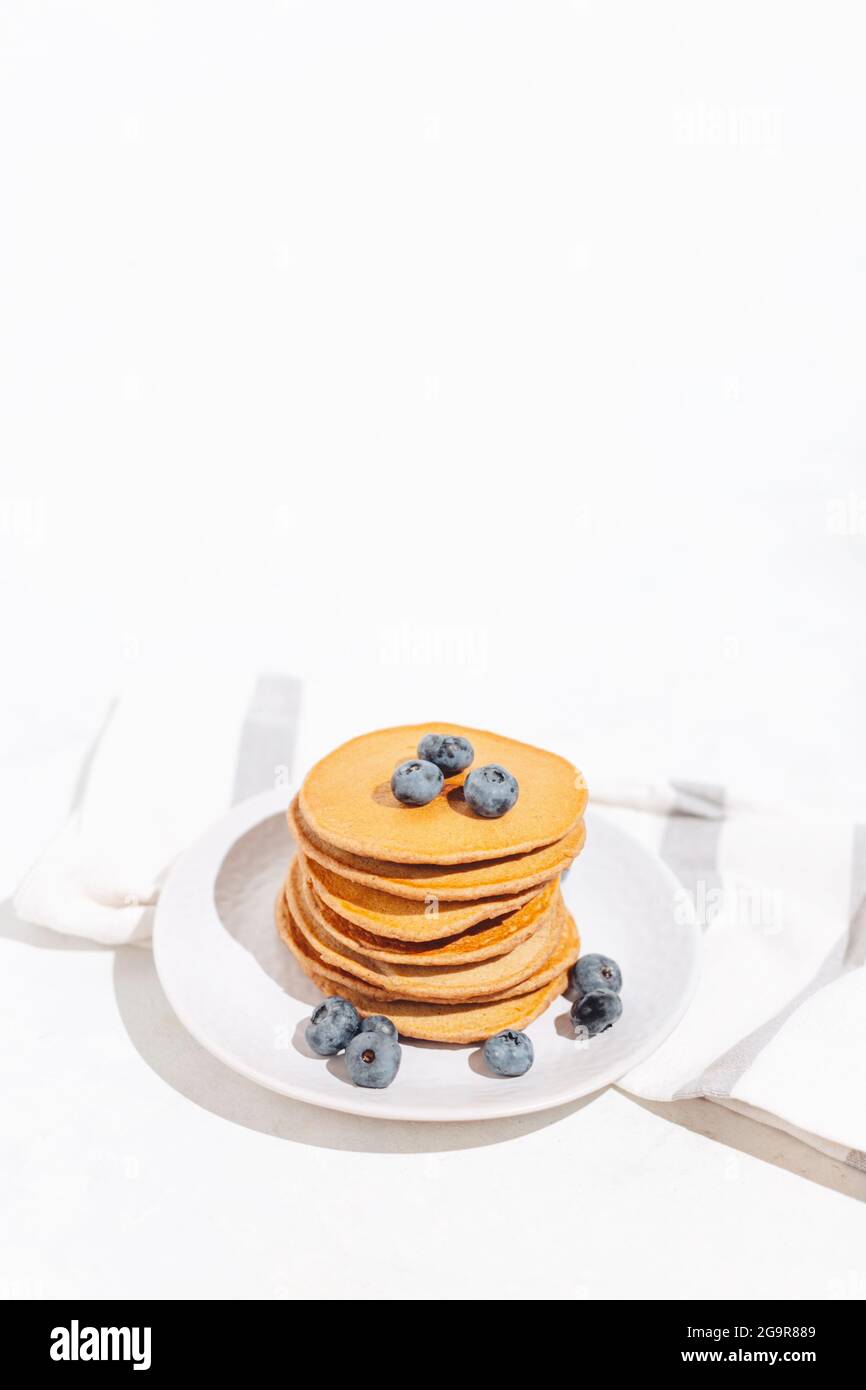 Amerikanische Pfannkuchen mit Heidelbeeren auf weißem Hintergrund mit Tuch Stockfoto