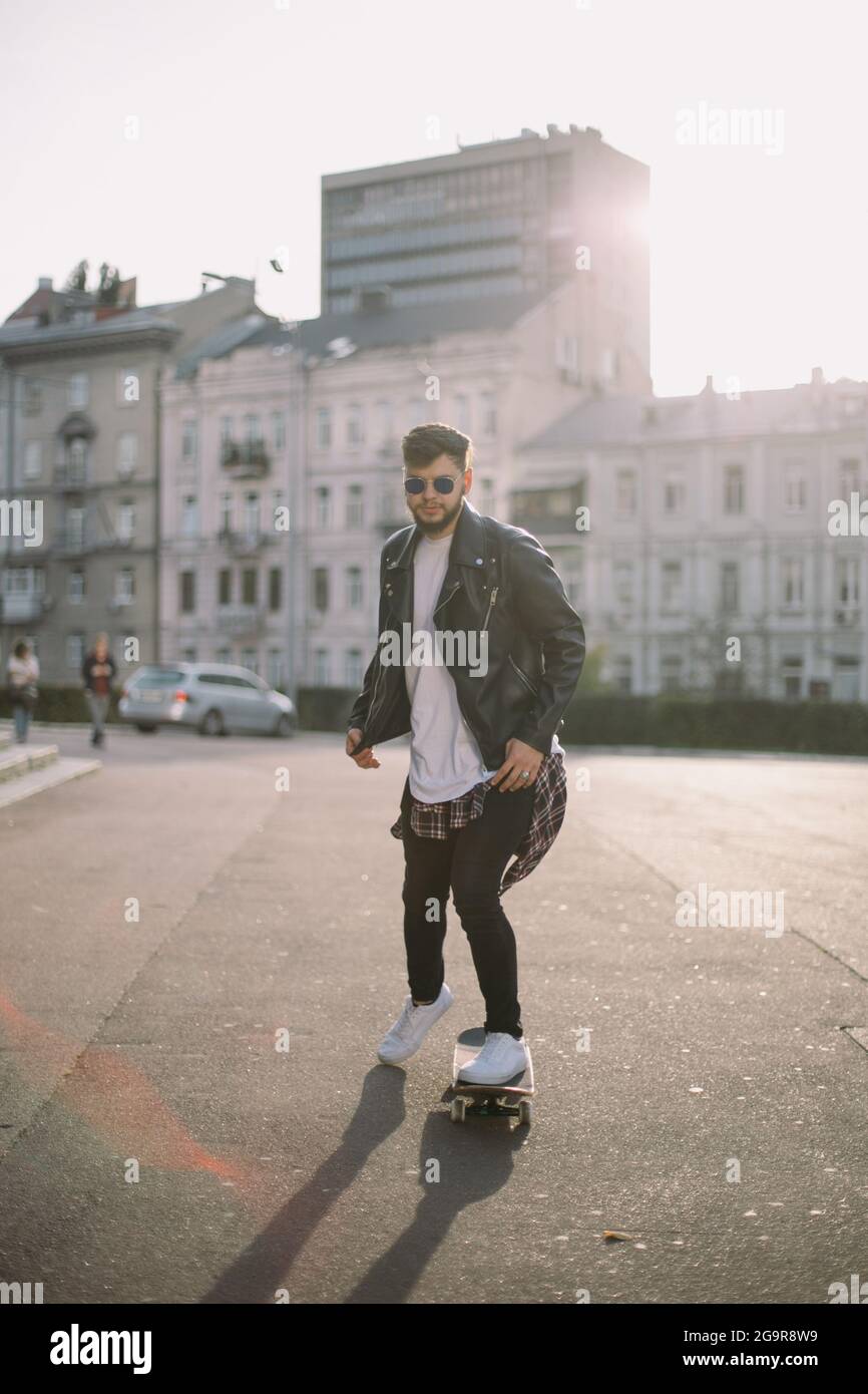 Hipster Mann in der Stadt Porträt trägt Brille Skateboarding Stockfoto