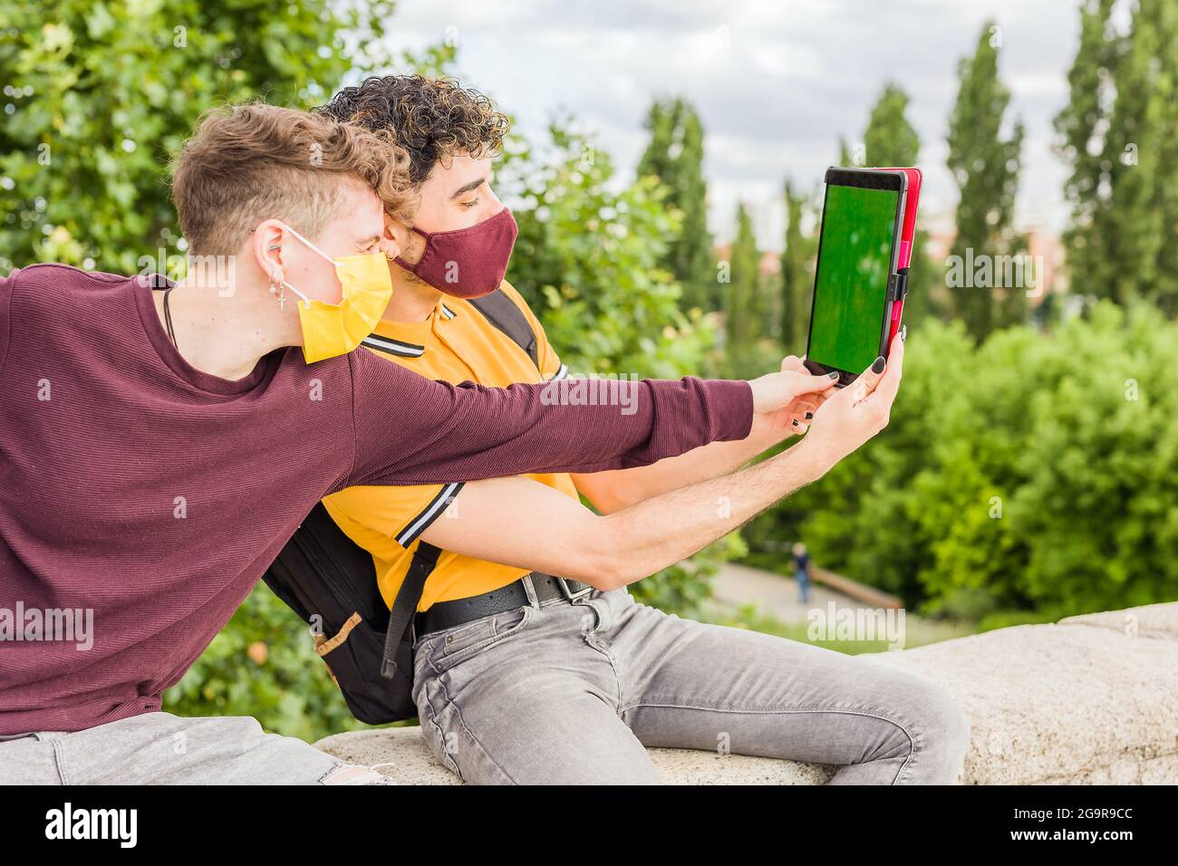 Lateinischer junger Mann verwendet ein digitales Tablet. Soziale Distanz bei einer neuen normalen Pandemie. Touchscreen mit Chroma-Taste Stockfoto