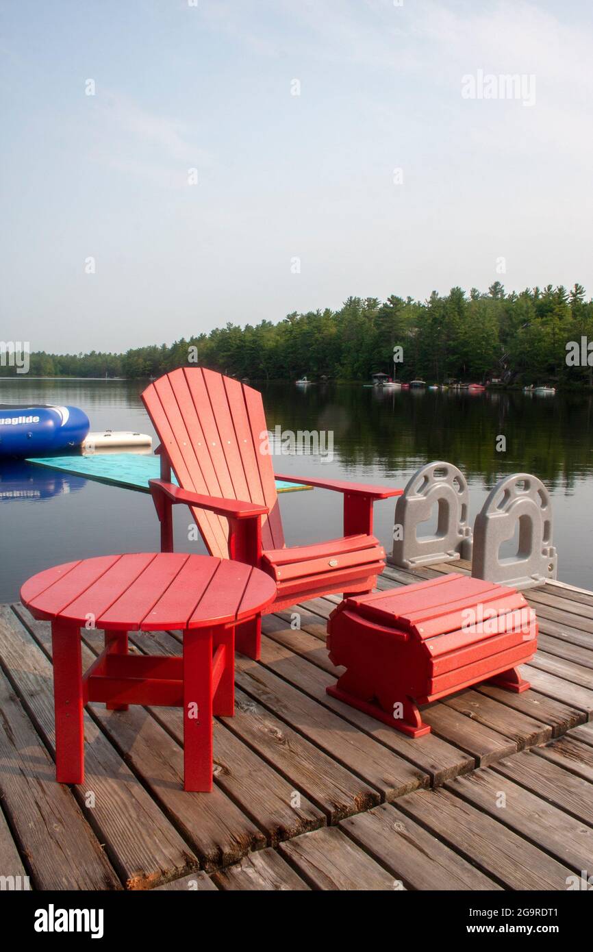 Ein Stuhl und ein Tisch auf dem Dock einer Hütte in Muskoka, Ontario Stockfoto