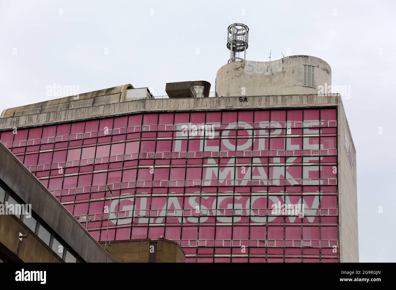 Menschen machen Glasgow Slogan auf einem Stadtgebäude Stockfoto