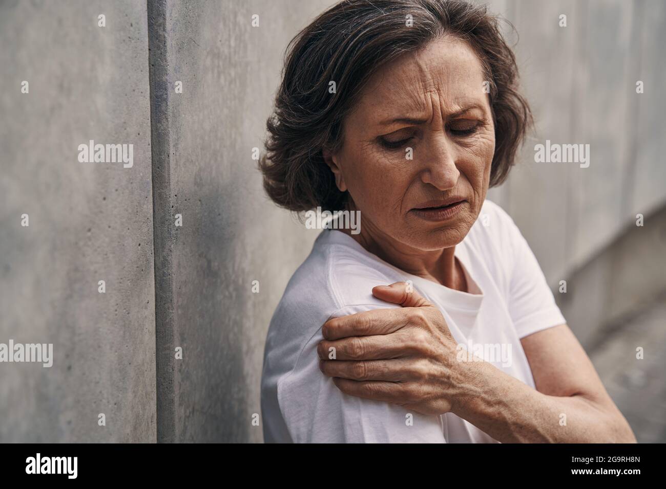 Reife aktive Dame, die beim Training im Freien verletzt wird Stockfoto