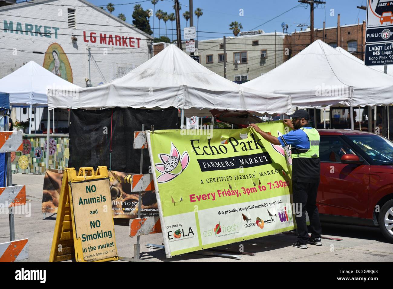 Los Angeles, CA USA - 24. Juni 2021: Mann hängt Banner für den Echo Park Farmers Market am Eingang Stockfoto