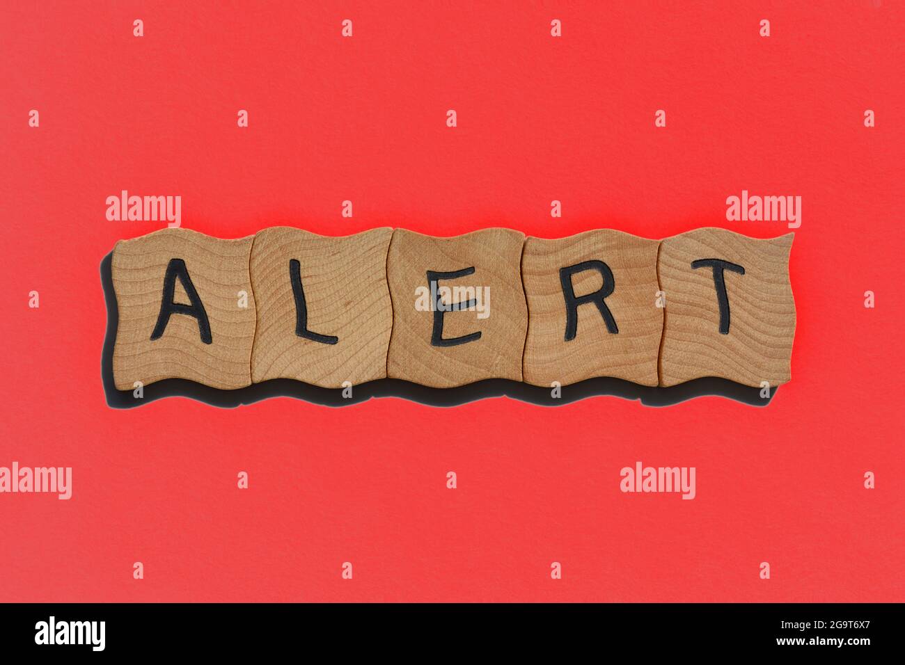 Alarm, Wort in hölzernen Buchstaben auf rotem Hintergrund isoliert Stockfoto