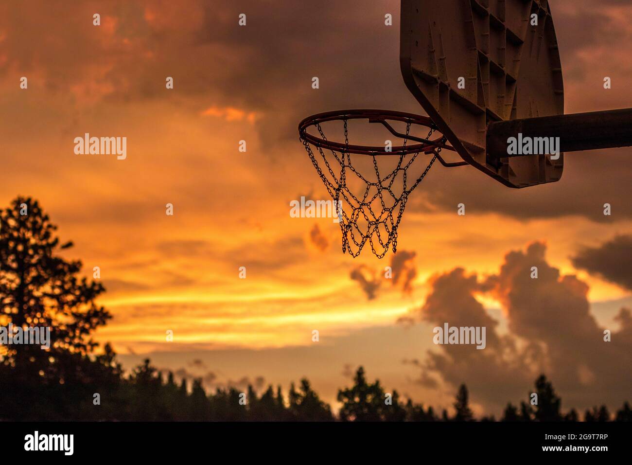 Hintergrundbeleuchtetes Stahlkettennetz für Basketball bei Sonnenuntergang Stockfoto