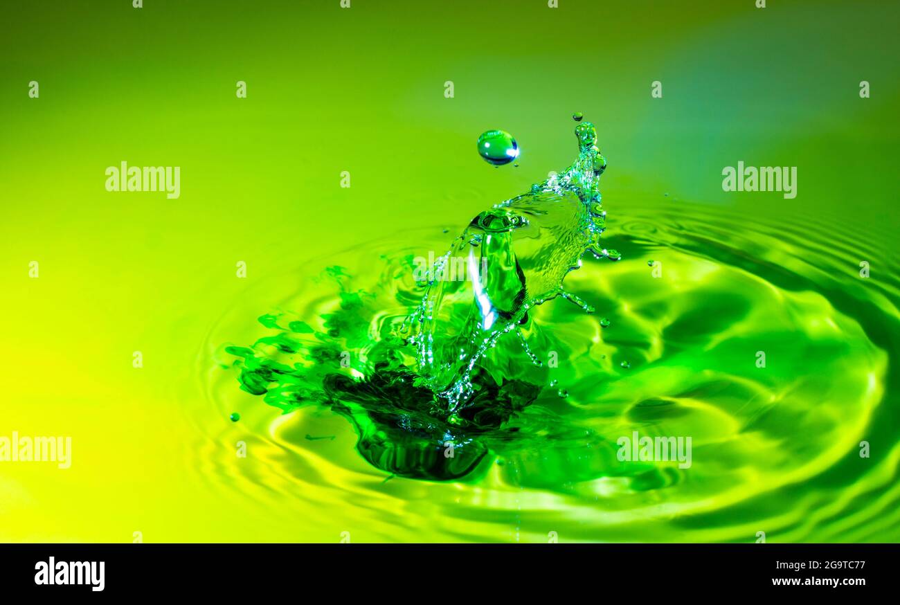 Kollision mit einem grünen Wassertropfen auf einer nahtlosen Oberfläche Stockfoto