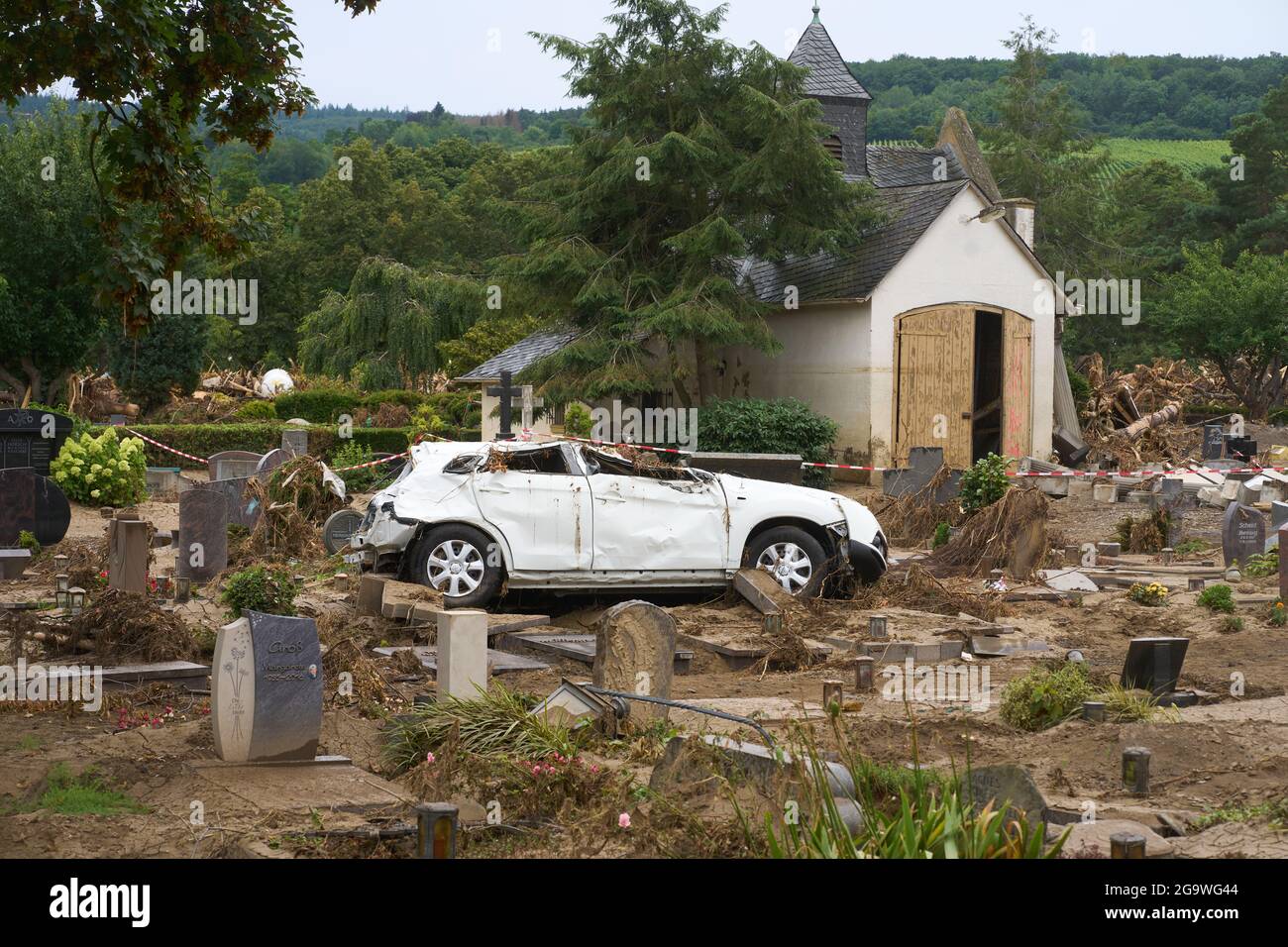 Ahrweiler, Deutschland. Juli 2021. Auf einem Grabfeld steht ein Auto, das während der Flutkatastrophe auf den Hannover Ahrweiler Friedhof gespült wurde. Der Friedhof ist total verwüstet. Quelle: Thomas Frey/dpa/Alamy Live News Stockfoto