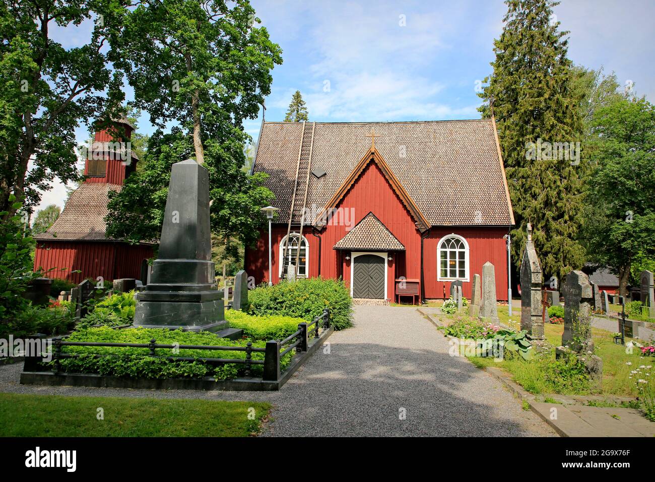 Sammatti Kirche, erbaut 1754–55. Links das Grab von Elias Lönnrot, dem Schöpfer des finnischen Nationalepos Kalevala. Sammatti, Finnland. Juni 2021. Stockfoto