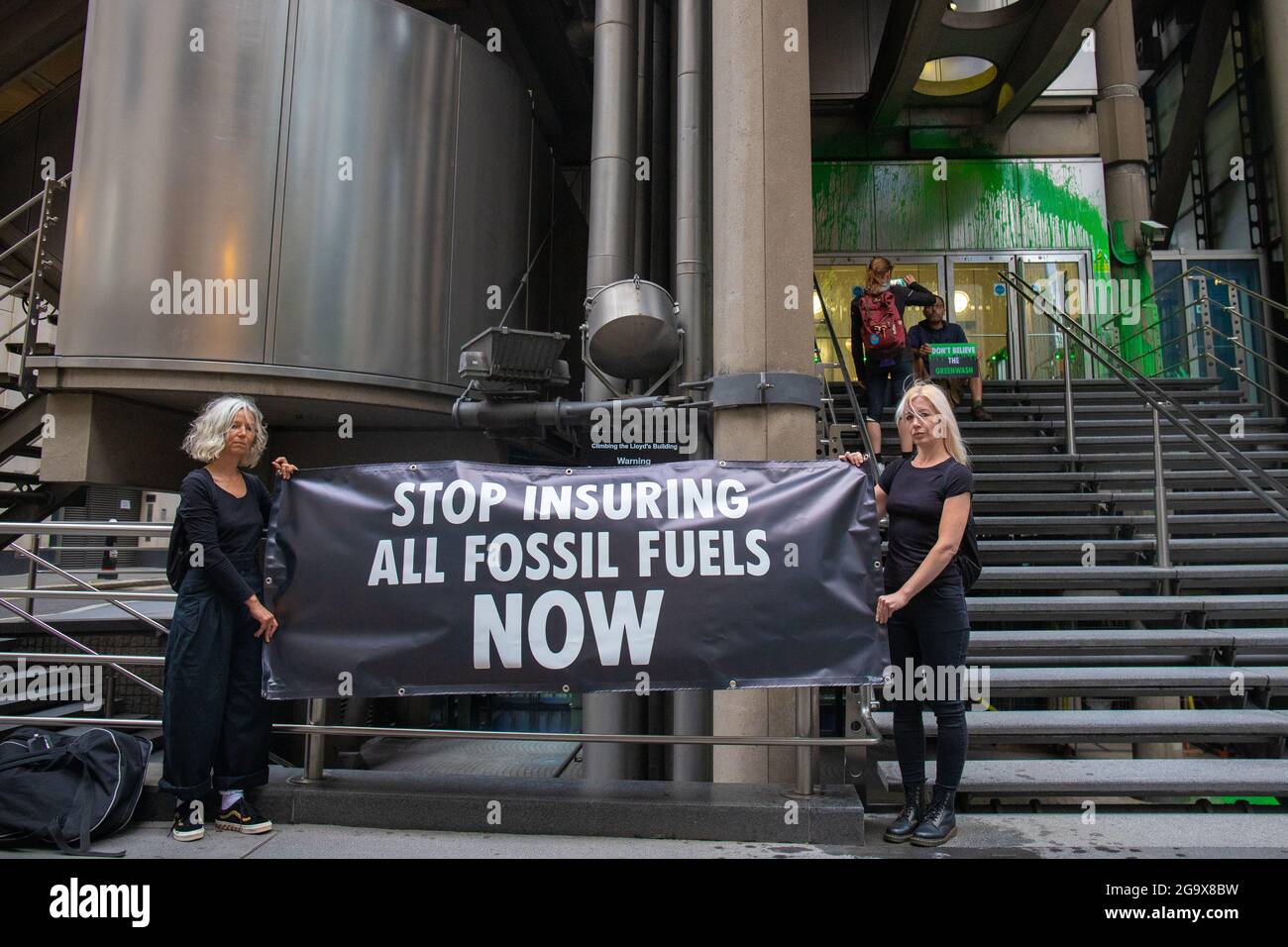 London, England, Großbritannien 28. Juli 2021 Insurance Rebellion wirft grüne Farbe über Lloyds of London, um ihre Greenwashing-Kampagne hervorzuheben. Ein Aktivist wurde verhaftet, nachdem er biologisch abbaubare, wasserbasierte, grüne Farbe über die Vorderseite des Gebäudes geworfen hatte. Der Protestierende, nachdem er die Farbe geworfen hatte, setzte sich hin und wartete auf die Ankunft der Polizei. Ein Sprecher sagte: „Lloyds gibt einfach vor, positive Klimaschutzmaßnahmen zu ergreifen, während es immer noch Teile der fossilen Energiewirtschaft ermöglicht“. Stockfoto