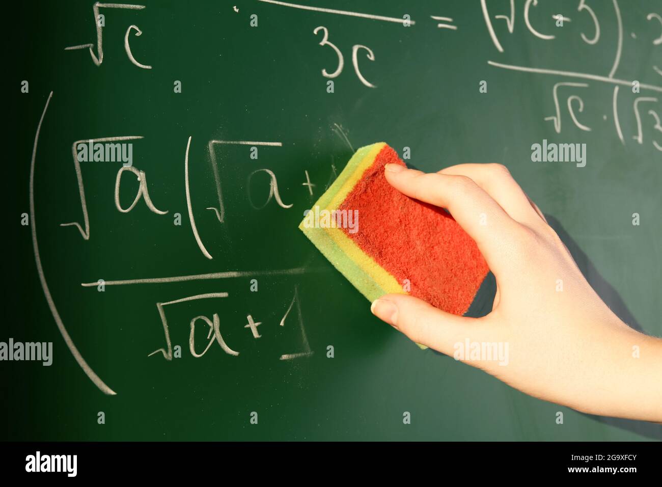 Lehrer Hand wischen Formeln auf Tafel Hintergrund Stockfotografie - Alamy