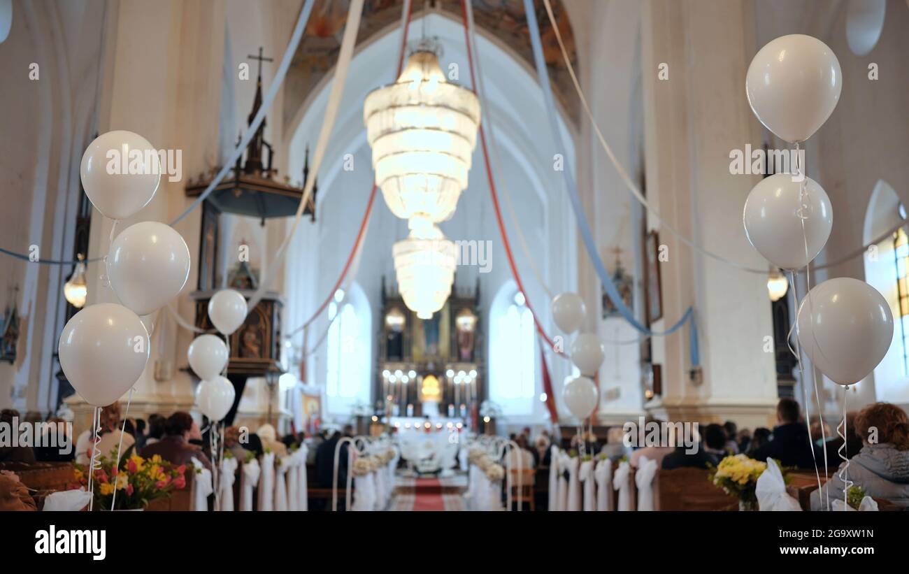 Weiße Kugeln in einer katholischen Kirche während eines Gottesdienstes. Stockfoto