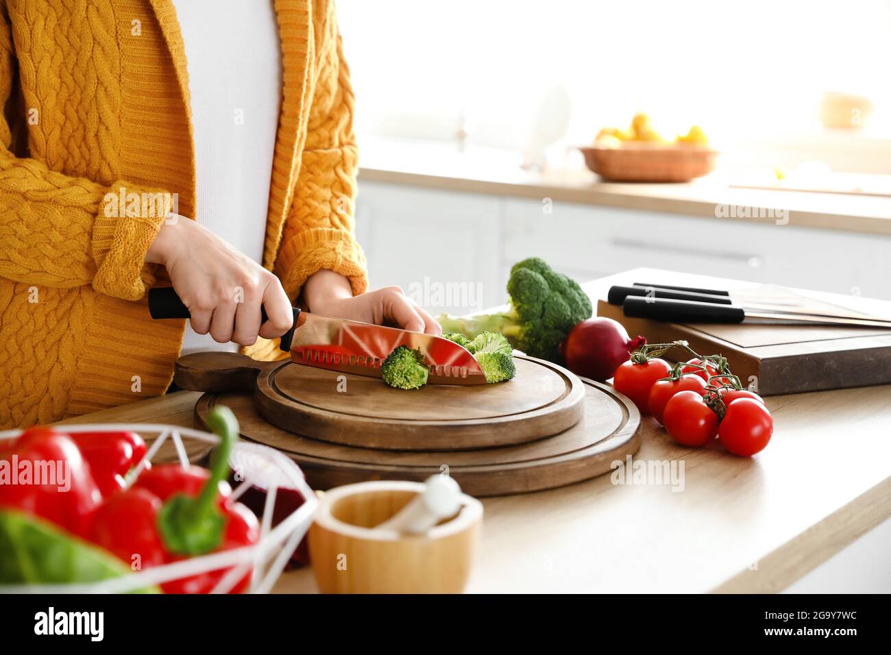 Frau schneidet Brokkoli in der Küche, Nahaufnahme Stockfoto