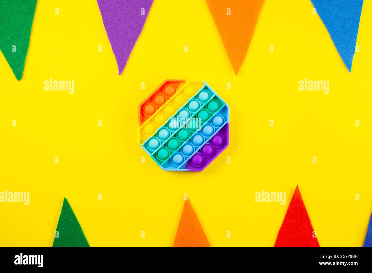 Antistress-Pop-it-Spielzeug. Rainbow Silikon sensorische Fidget auf farbivollem Hintergrund. Neue beliebte trendige Silikon-Spielzeug. Stockfoto