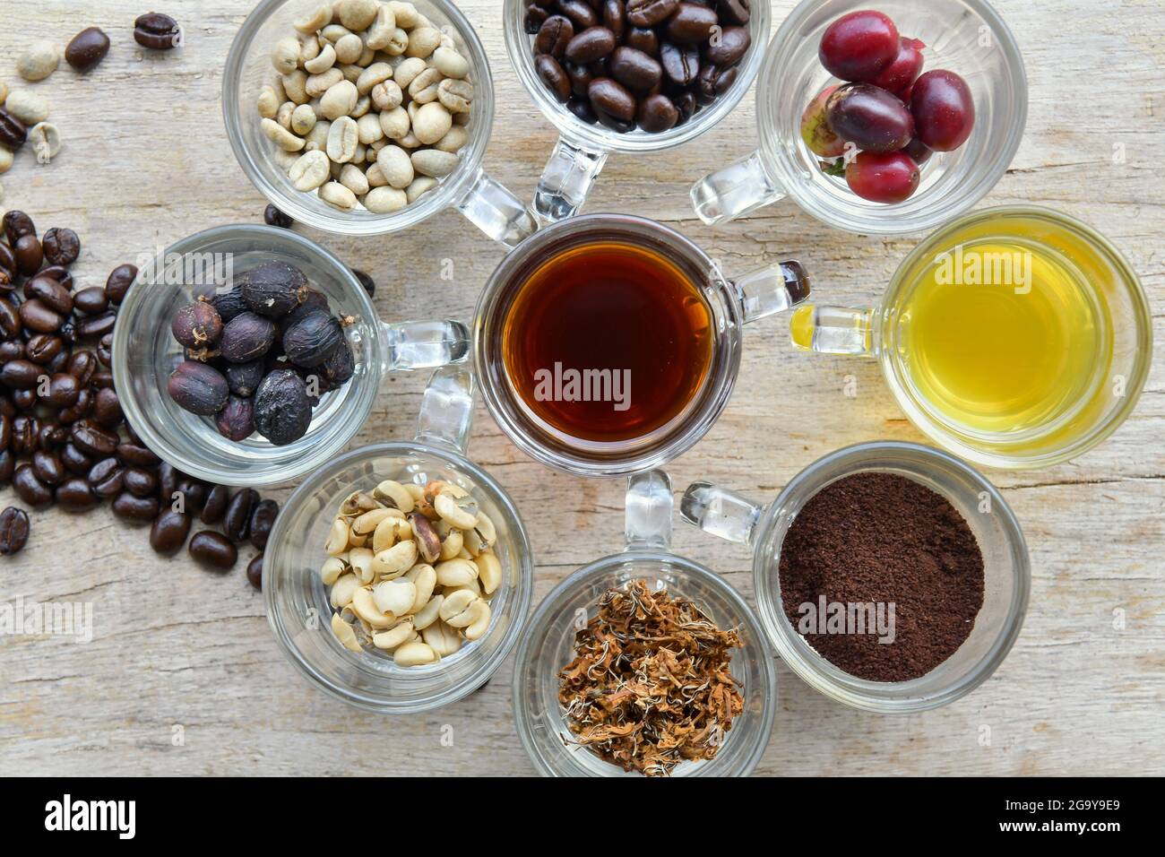 Blick von oben auf verschiedene Tassen mit Kaffee, Kaffeebeeren und Kaffeebohnen Stockfoto