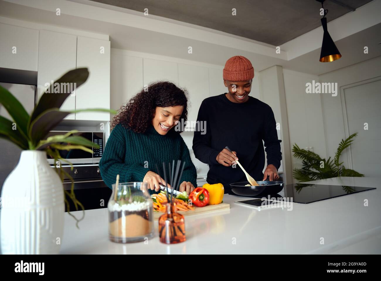 Junges gemischtes Rennpaar, das in der Küche zu Hause kocht. Paar bereiten Essen zu. Hochwertige Fotos Stockfoto