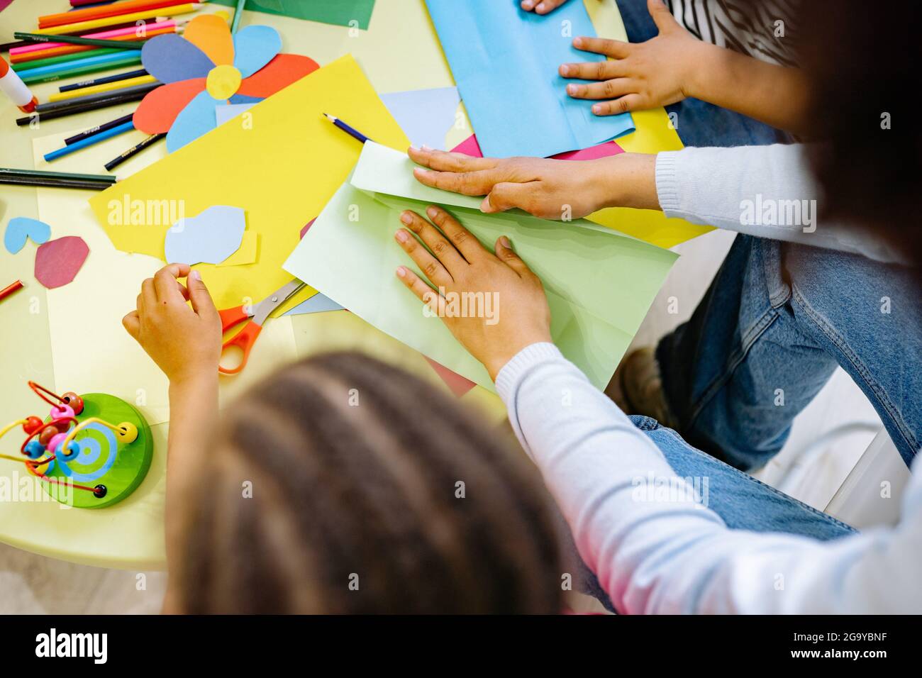 Frauen und Kinder machen Kunst mit farbigen Papieren Stockfoto