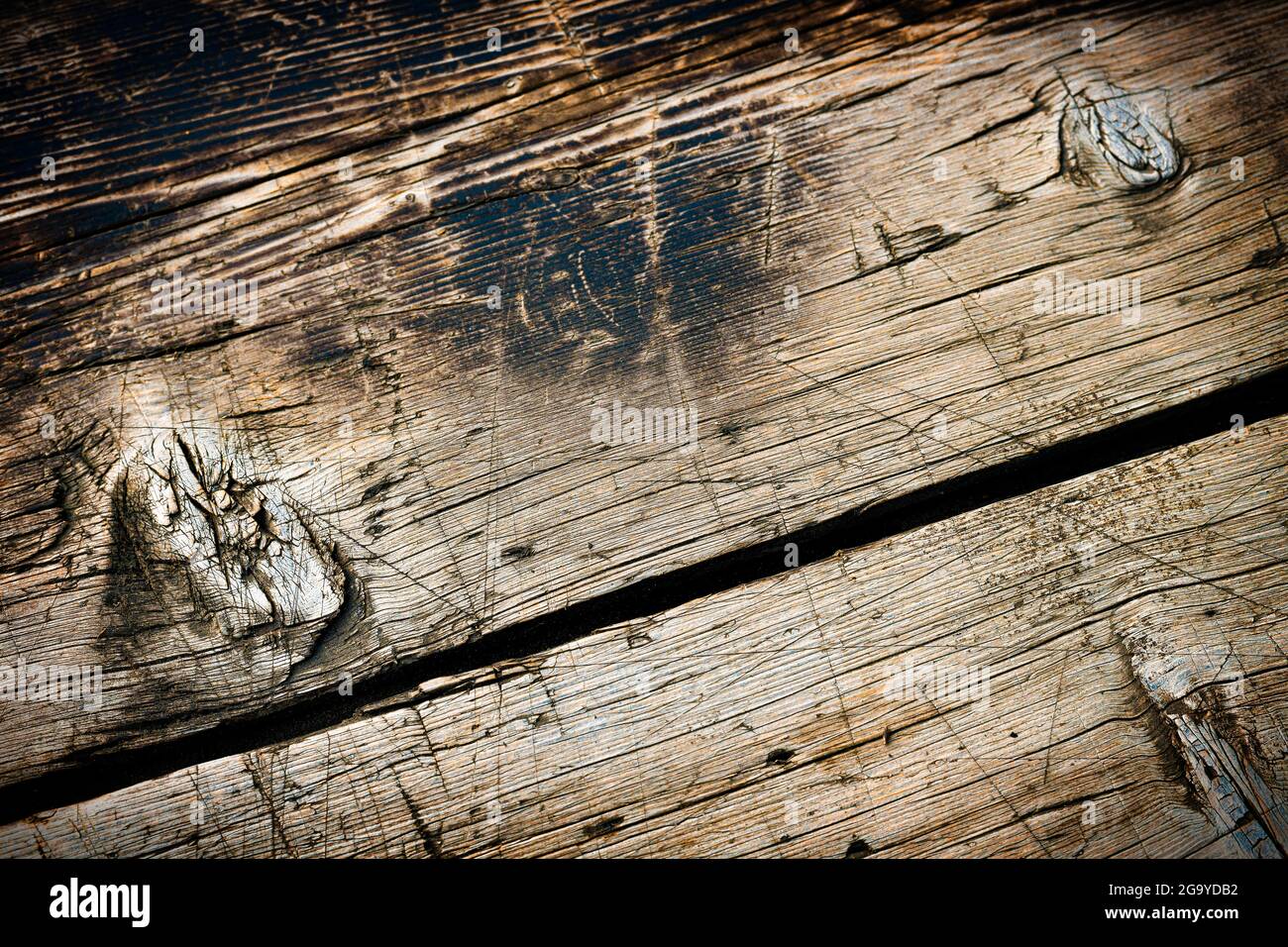 Holzhintergrund mit schräg geknüpftem Aged-Muster. Rahmen mit Lichteffekt. Stockfoto