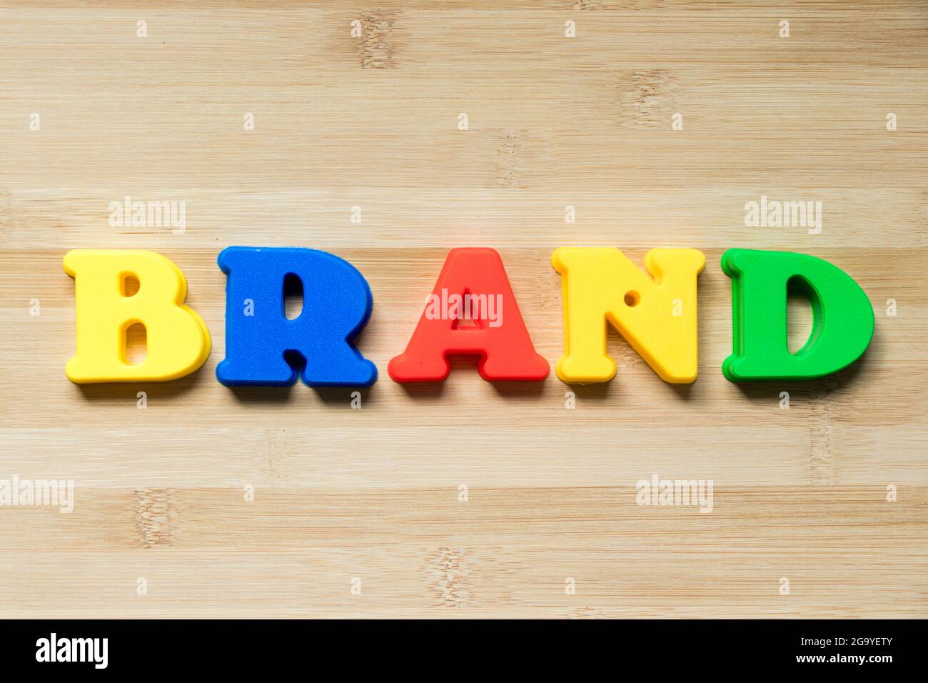 Farbe Kunststoff Alphabet in Wort Marke auf Holz Hintergrund Stockfoto
