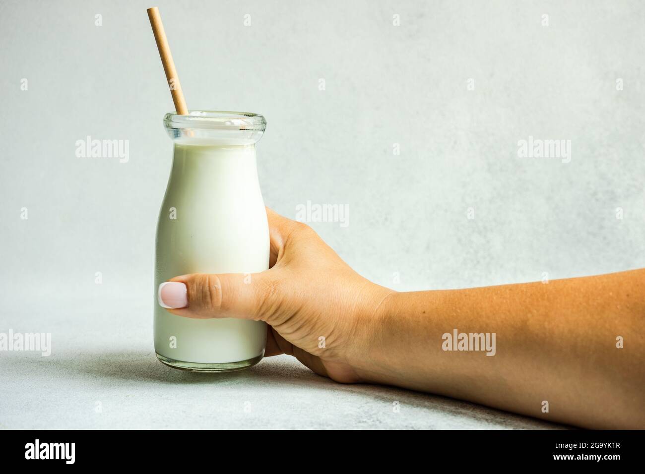 Frau, die eine Flasche Milch mit Trinkhalm hält Stockfoto