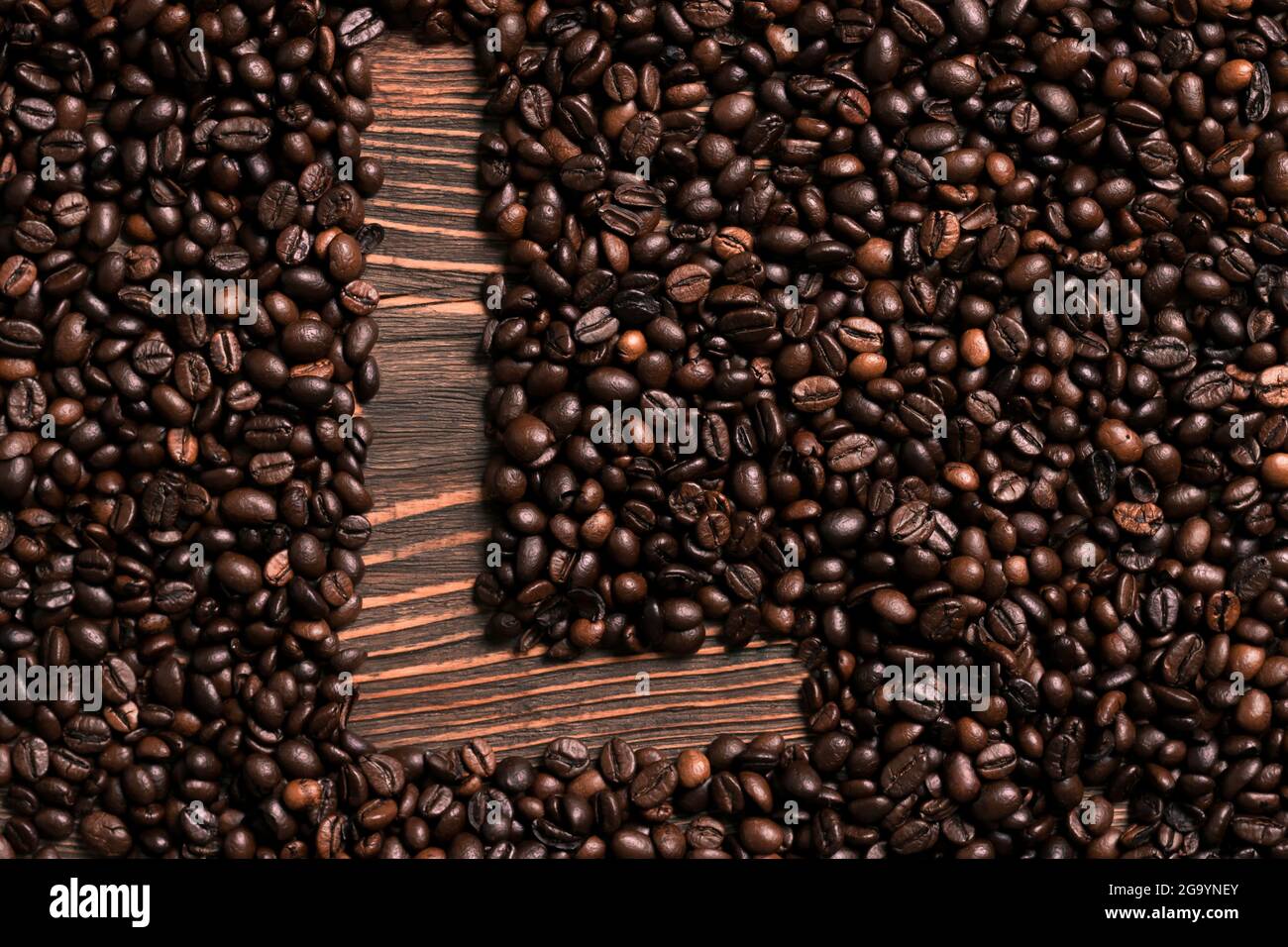 Buchstabe L Inschrift mit Kaffeebohne auf dem Holztisch Stockfoto