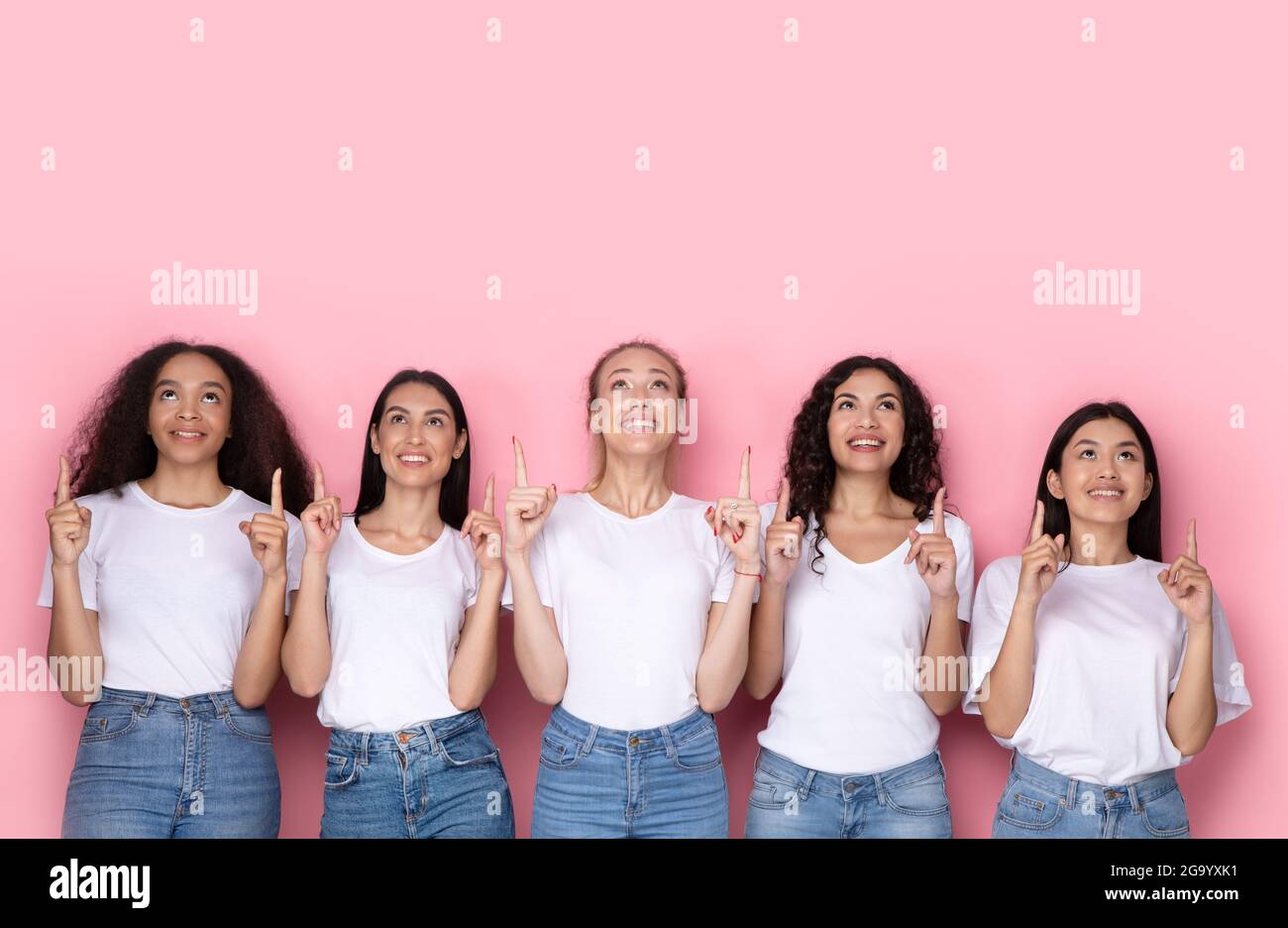 Gruppe Von Fünf Verschiedenen Weibchen, Die Die Finger Nach Oben Zeigen, Rosa Hintergrund Stockfoto