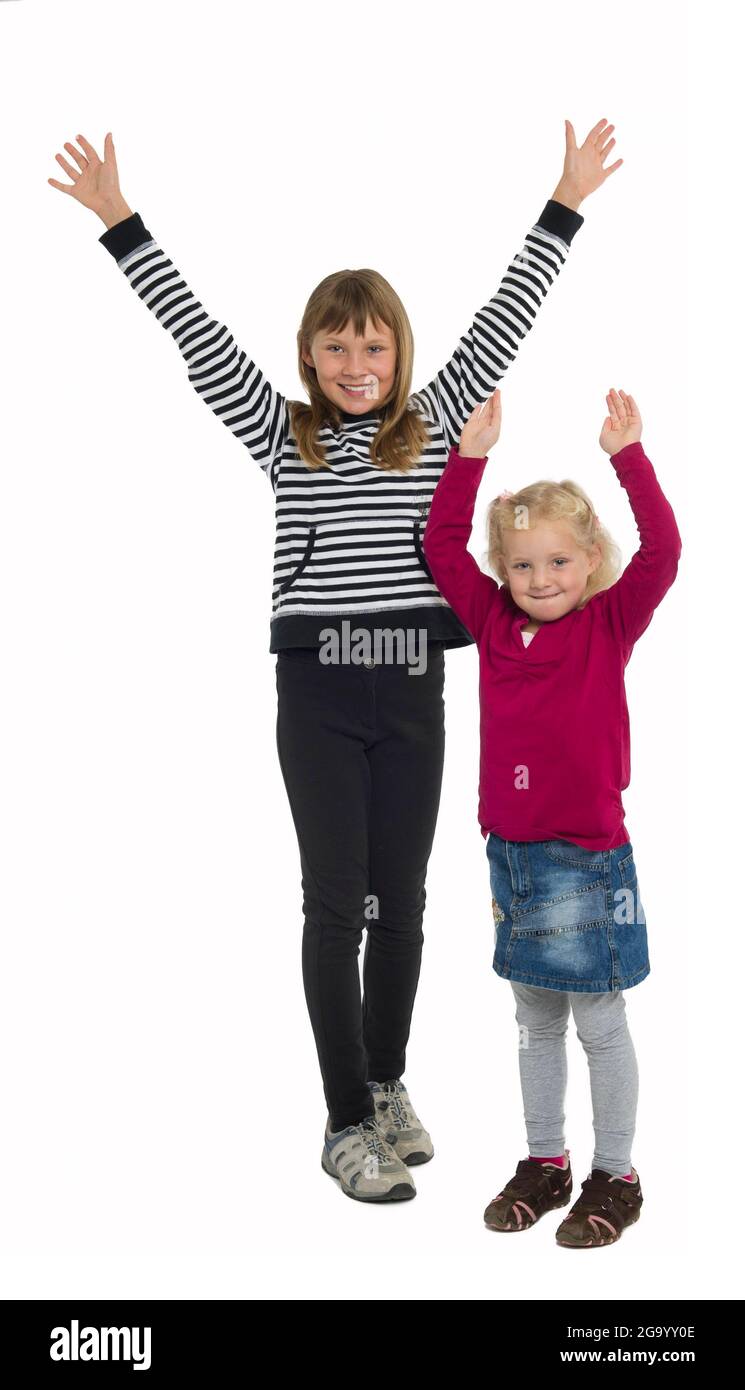 Zwei fröhliche Schwestern werfen ihre Arme in die Luft Stockfoto