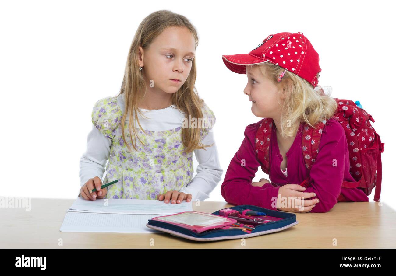 Kindergartner mit Rucksack, der eine Schwester bei Hausaufgaben stört Stockfoto