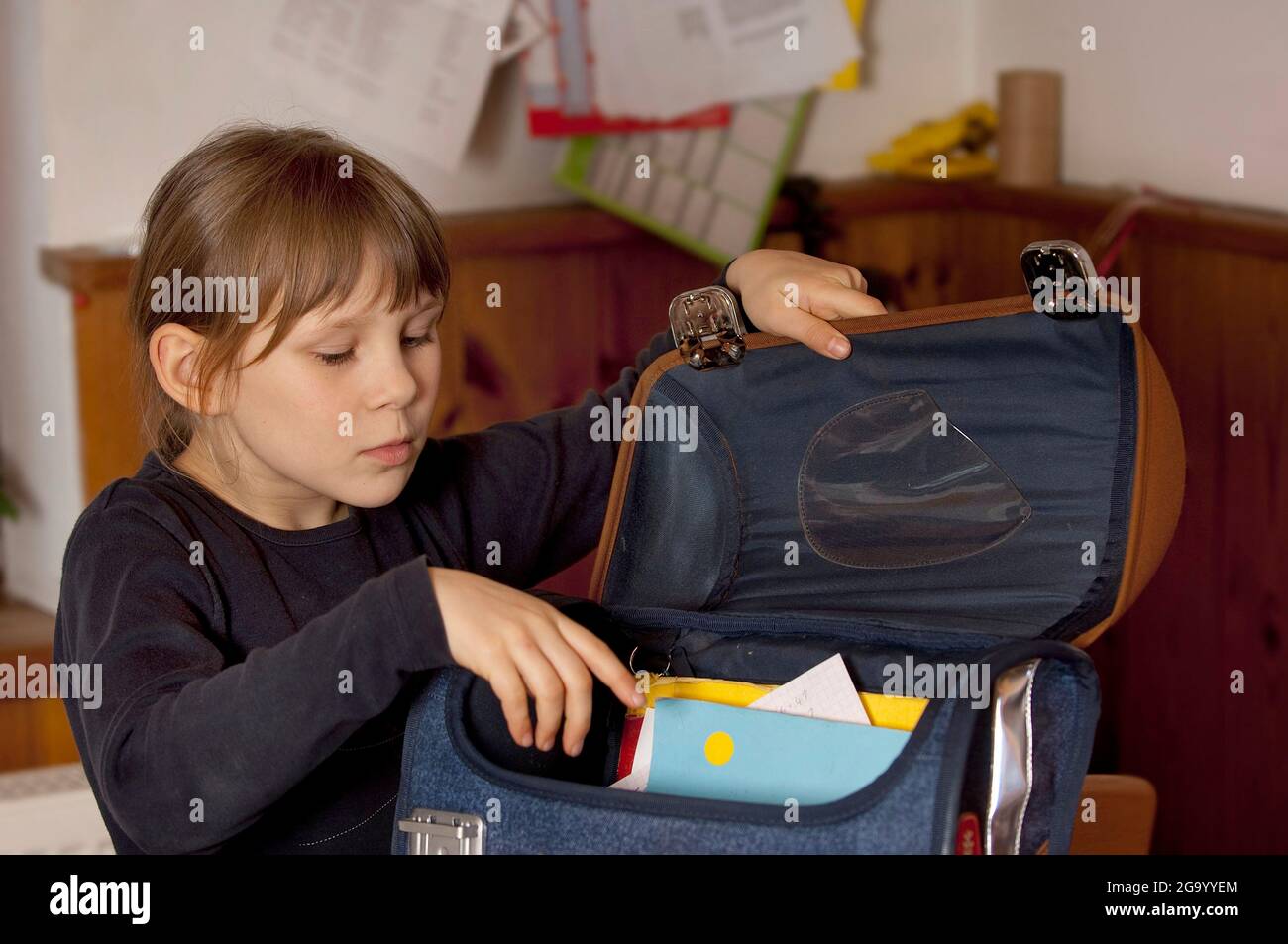 Grundschülerin, die ihre Tasche packt, Deutschland Stockfoto
