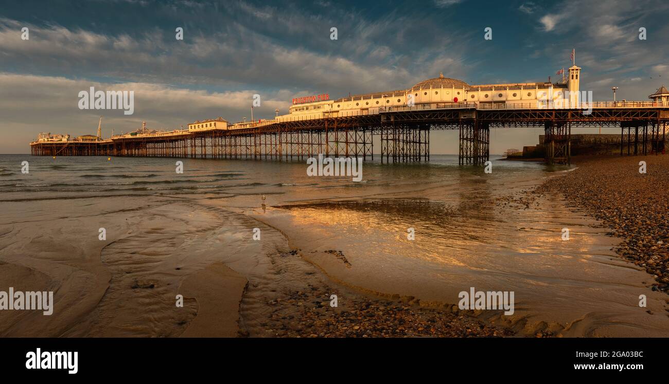 Brighton Pier in der Morgensonne mit Ebbe Meer und Reflexion, England Stockfoto