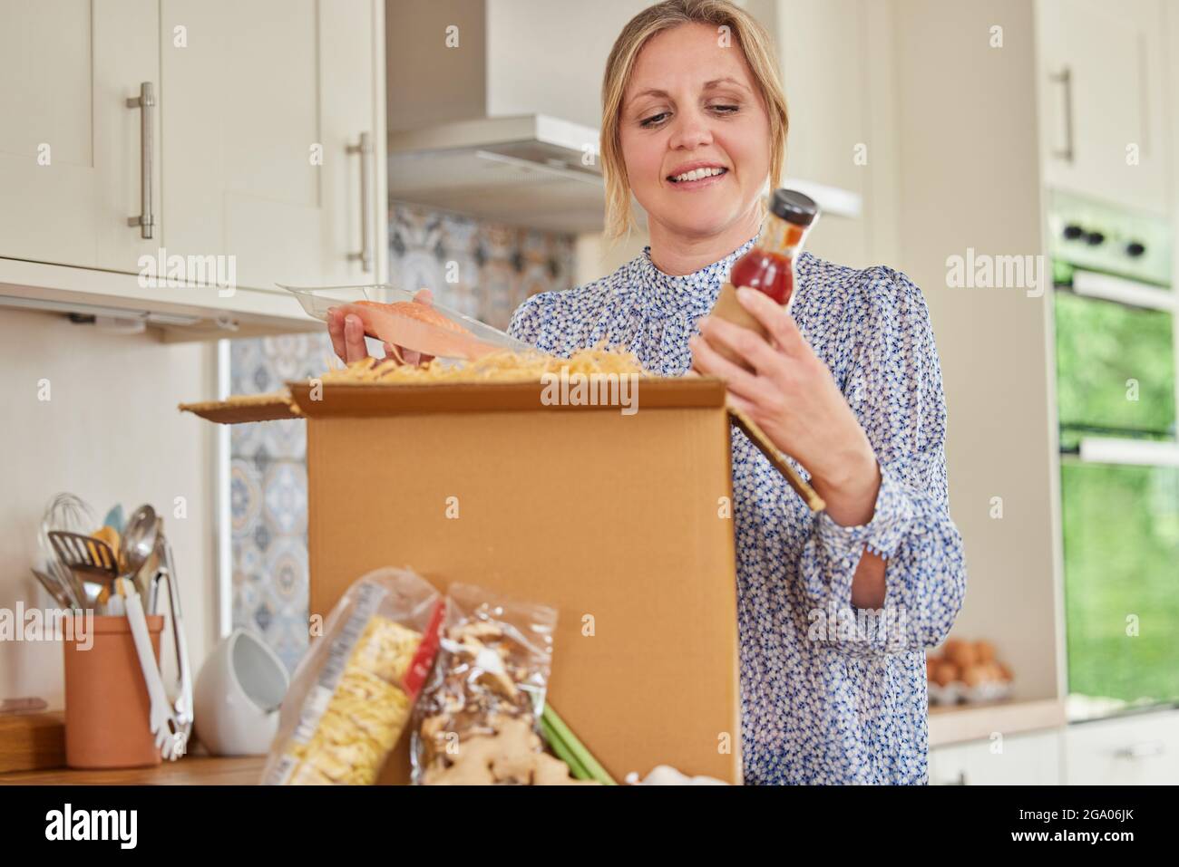 Frau Auspacken Online Essen Rezept Kit Nach Hause Geliefert Stockfoto