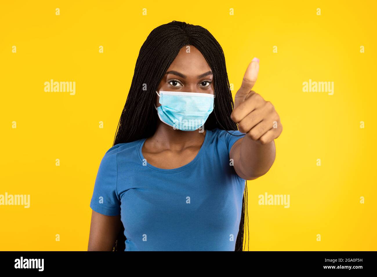 Schwarze Frau Trägt Gesichtsmaske Gestikulierenden Daumen-Up Über Gelbem Hintergrund Stockfoto