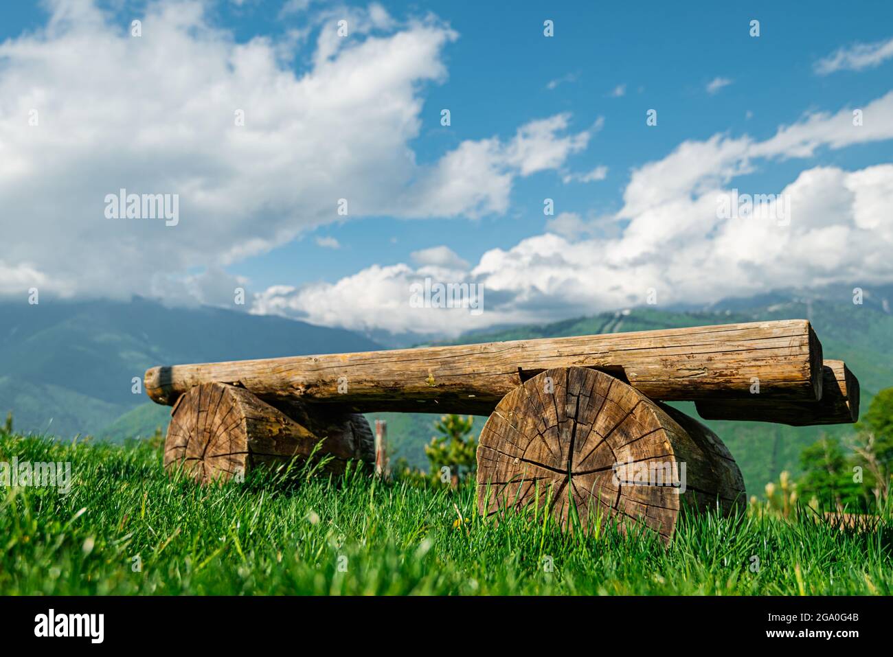 Eine Holzbank in Nahaufnahme vor dem Hintergrund einer Berglandschaft. Berglandschaft des Nationalparks Sotschi Russland. Stockfoto