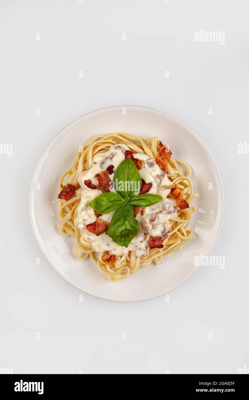Spaghetti und Sauce auf einem Teller auf isoliertem Studiohintergrund Stockfoto