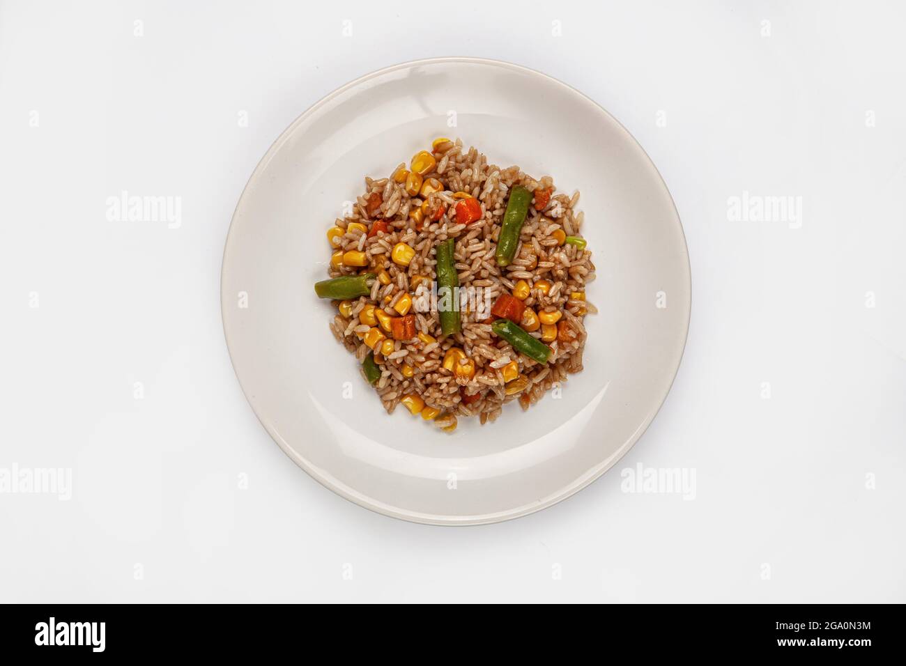 Gerösteter Reis und Gemüse auf einem Teller auf isoliertem Hintergrund Stockfoto