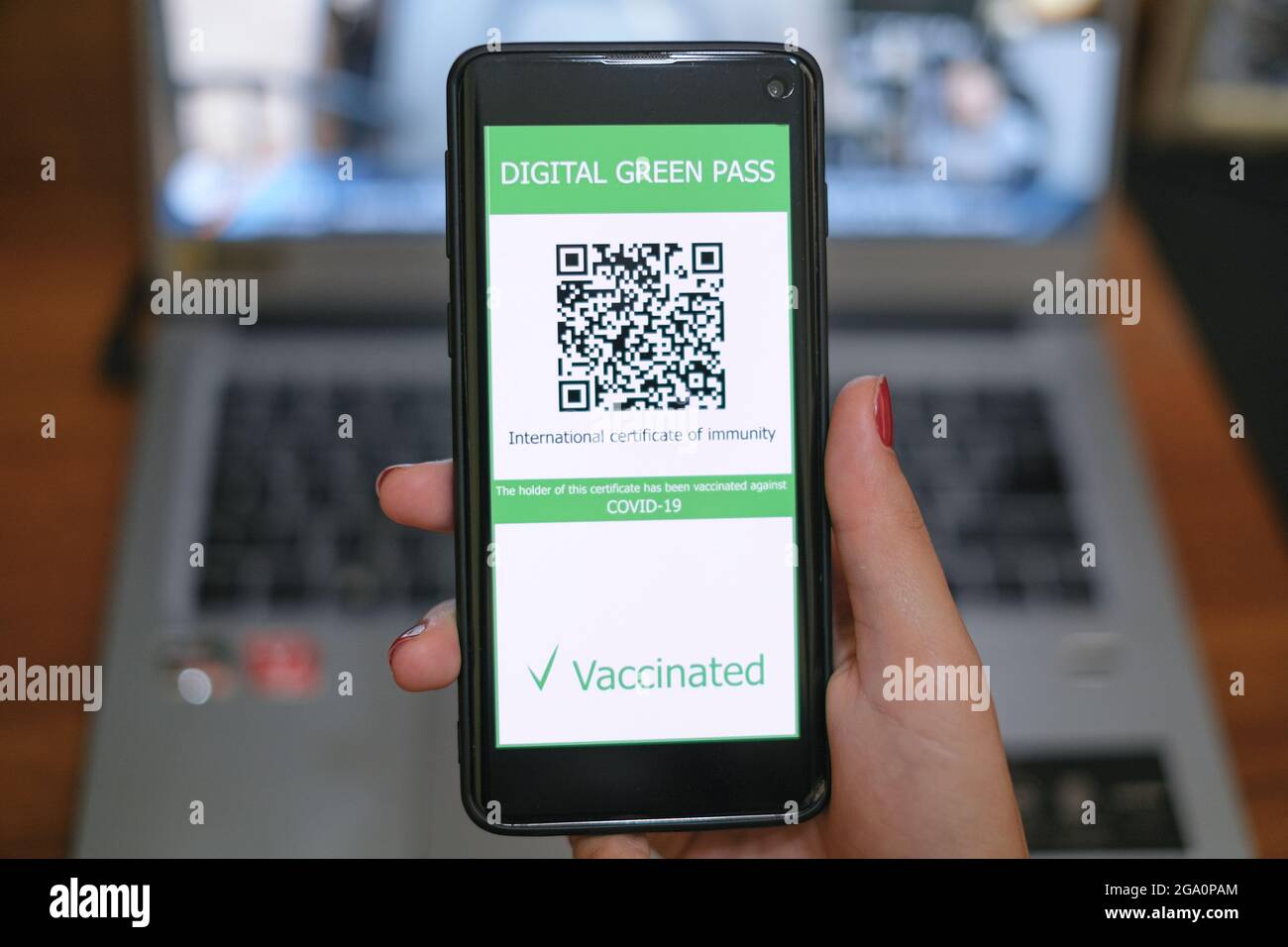 Frau hält covid19 Impfstoff qr-Code Green Pass Zertifikat auf einem Smartphone, Tech Stockfoto