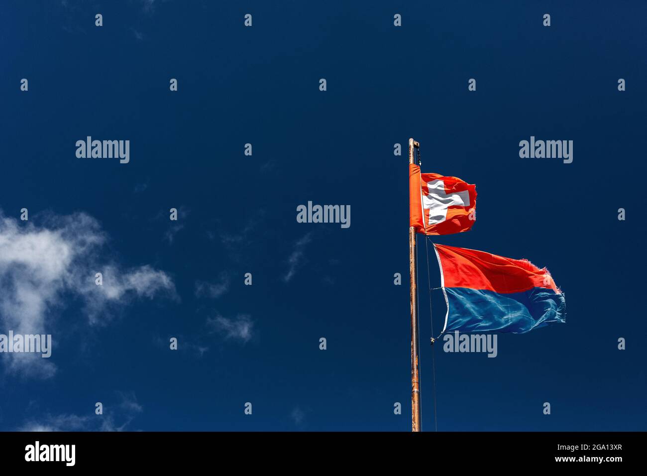 Stock mit wehenden Schweizer Flaggen und Lichtenstein Fahnen am blauen Himmel Stockfoto