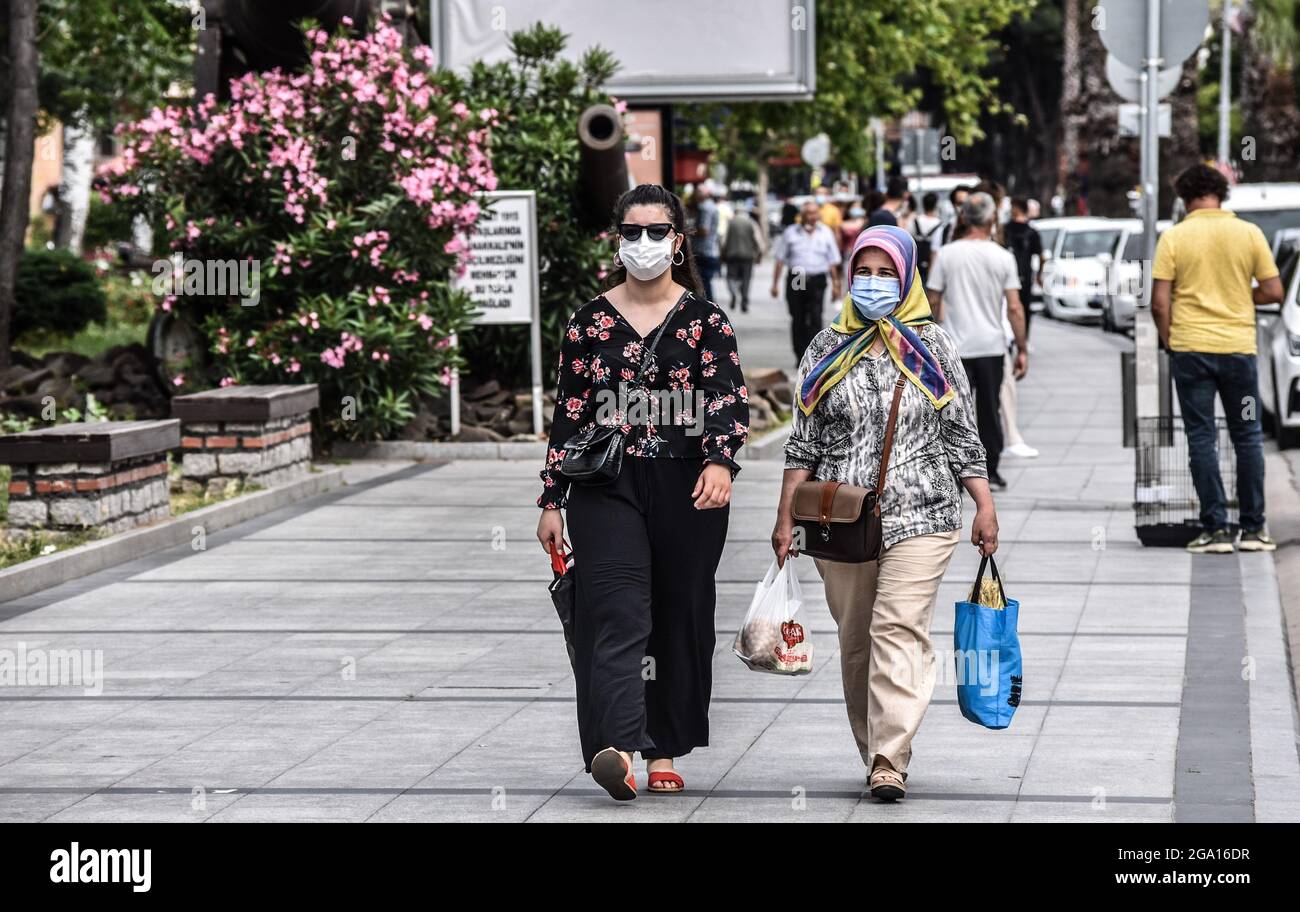 Menschen mit schützenden Gesichtsmasken gehen am Montag, den 7. Juni 2021, in einer Straße inmitten der Coronavirus-Pandemie (COVID-19) in Canakkale, Türkei, spazieren. (Foto von Altan Gocher/GocherImagery/Sipa USA) Stockfoto