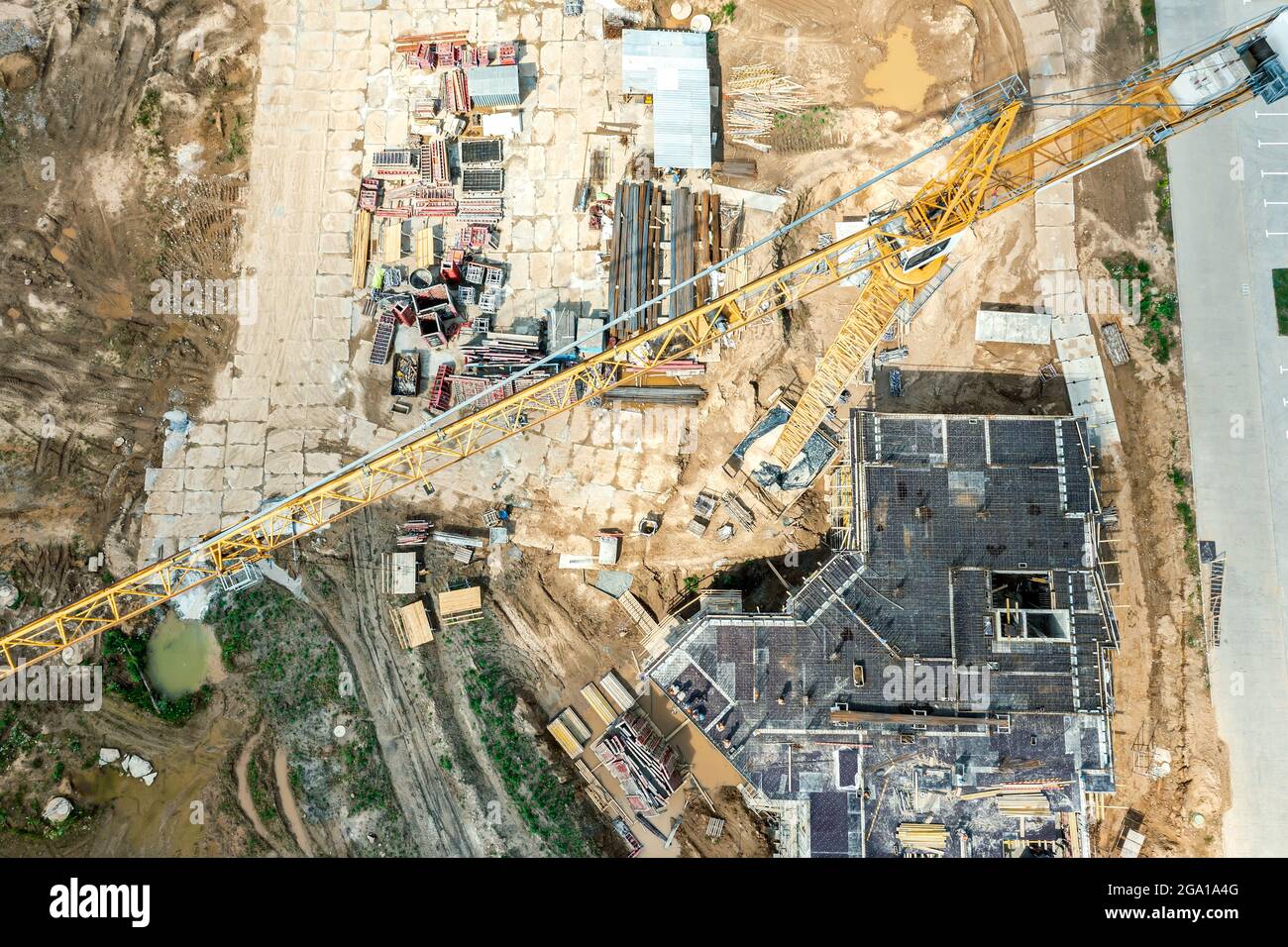 Luftaufnahme der Bauarbeiten. Bau der Fundamente auf der Baustelle mit einem gelben Kran. Stockfoto