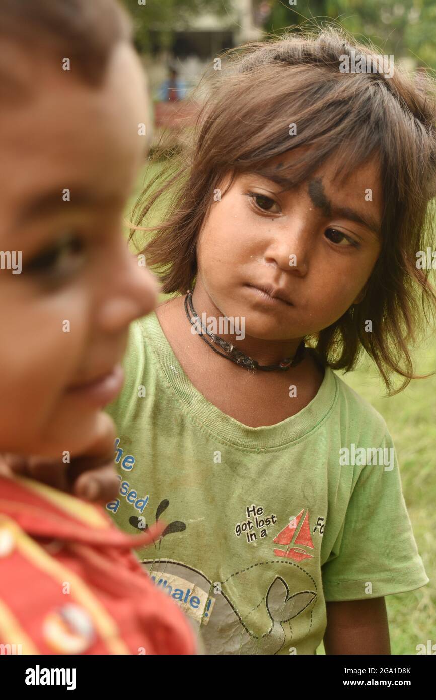 Indian Street Kid, Arme Mädchen Reinigung Wange eines Jungen Stockfoto