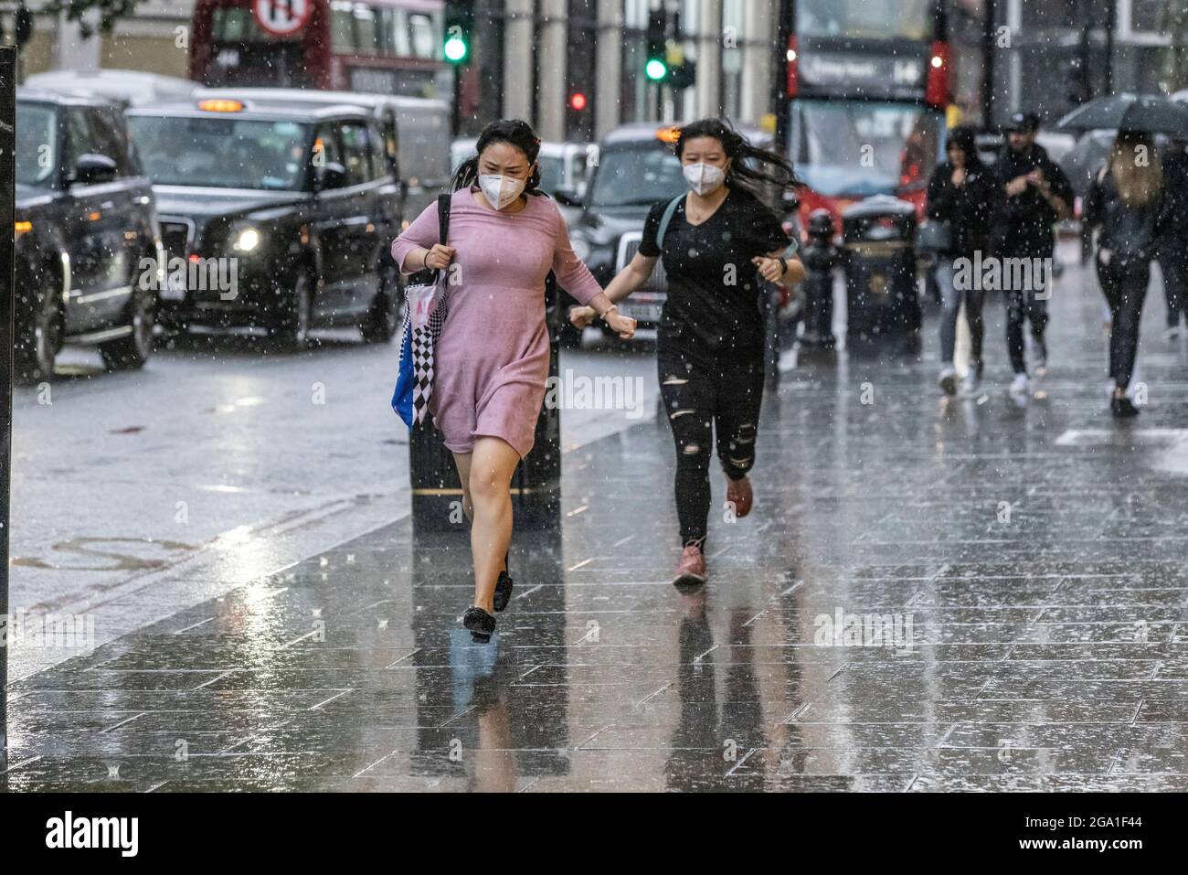 London, Großbritannien. 28 2021. Juli: Heftige Regenschauer treffen Knightsbridge, Central London, England, Großbritannien das Bild zeigt Touristen, die im Regen um Deckung laufen, während starke Regenschauer über das Zentrum Londons und den Süden Englands ziehen. Kredit: Clickpics/Alamy Live Nachrichten Stockfoto