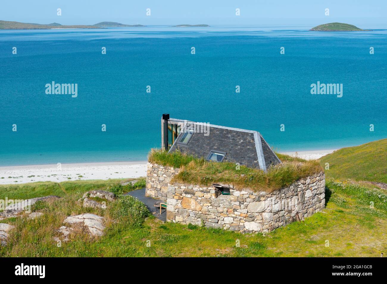 Kleines altes Häuschen, das in ein modernes Haus auf der Insel Eriskay mit Blick auf Sound of Barra, Schottland, Großbritannien, umgewandelt wurde Stockfoto