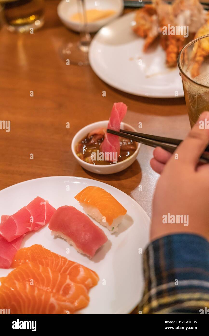 Frau frisst Sashimi mit Essstäbchen Stockfoto
