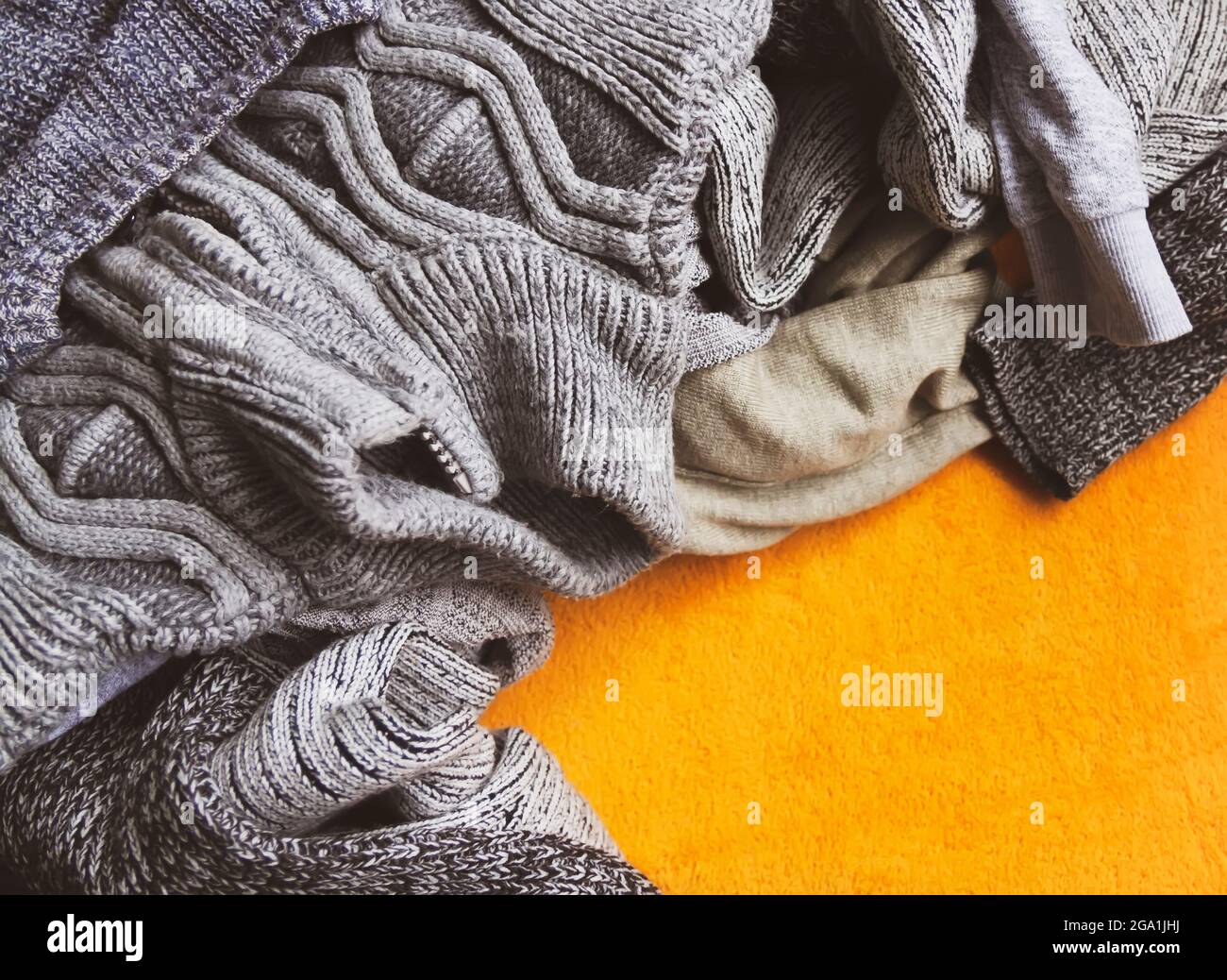 Warme Strickpullover und Pullover auf hellgelbem Hintergrund. Stockfoto