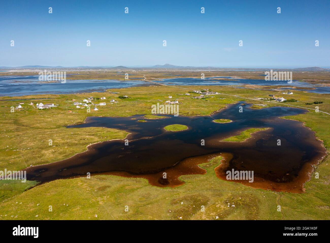Luftaufnahme von der Drohne des Dorfes Geirinis und der Ruine von Dun Mor Broch auf der Insel in South Uist, Äußere Hebriden, Schottland, Großbritannien Stockfoto