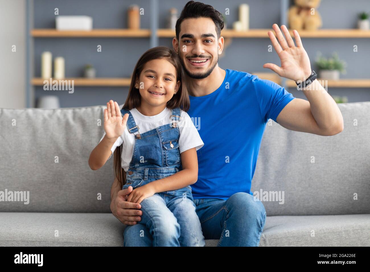 Familie winkt mit den Händen und posiert vor der Kamera Stockfoto