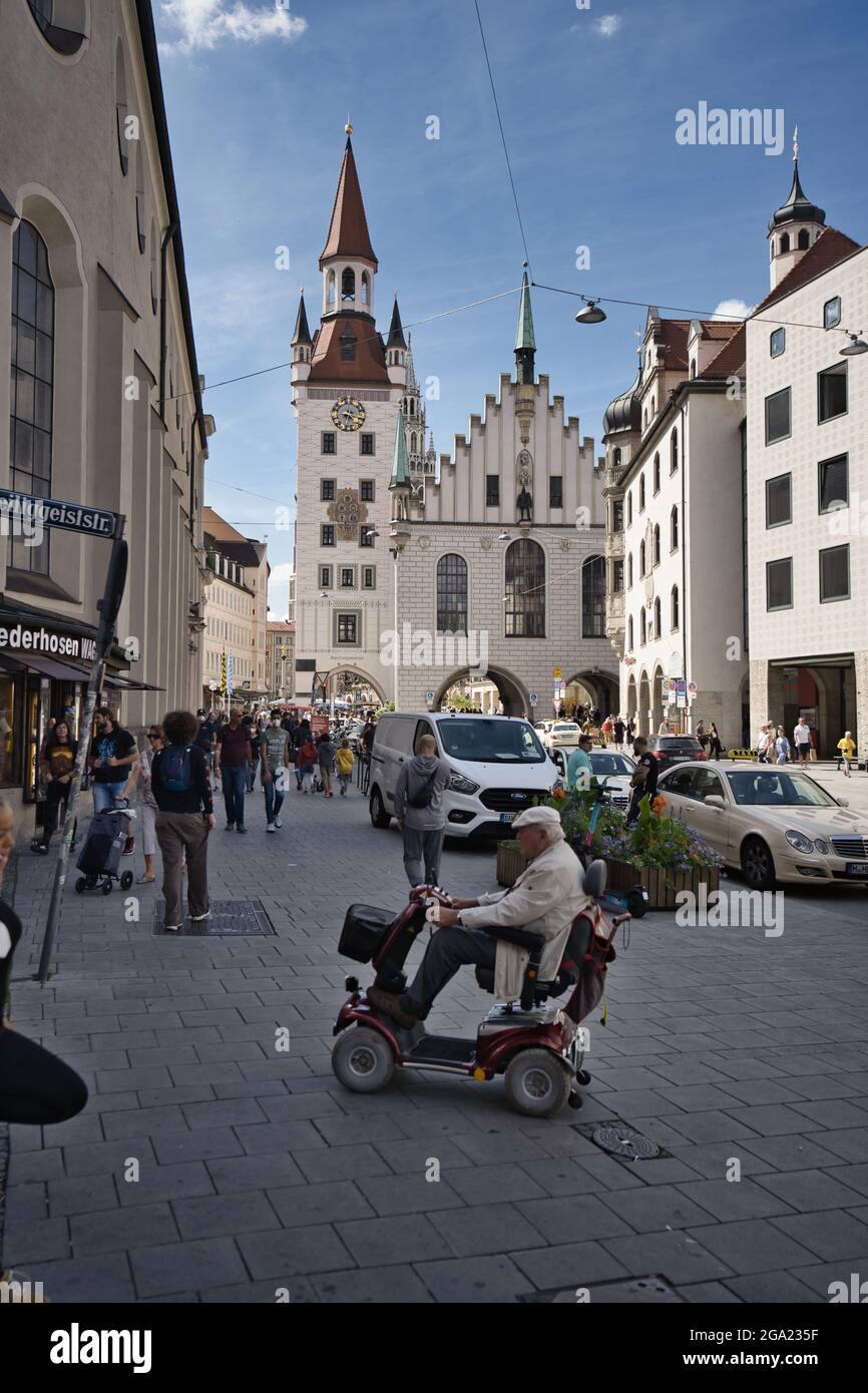 MÜNCHEN, DEUTSCHLAND - 16. Jul 2021: Eine vertikale Aufnahme von Menschen mit vielen Profilen, die die Straße in Richtung Marienplatz in München überqueren. Stockfoto