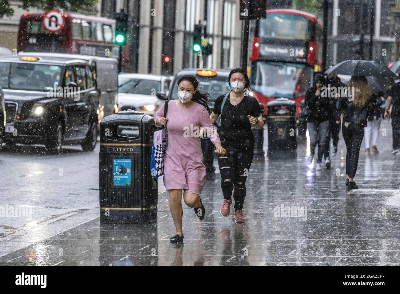 In Knightsbridge, im Zentrum von London, Großbritannien, laufen Touristen bei einem starken Regenguss nach Deckung Stockfoto