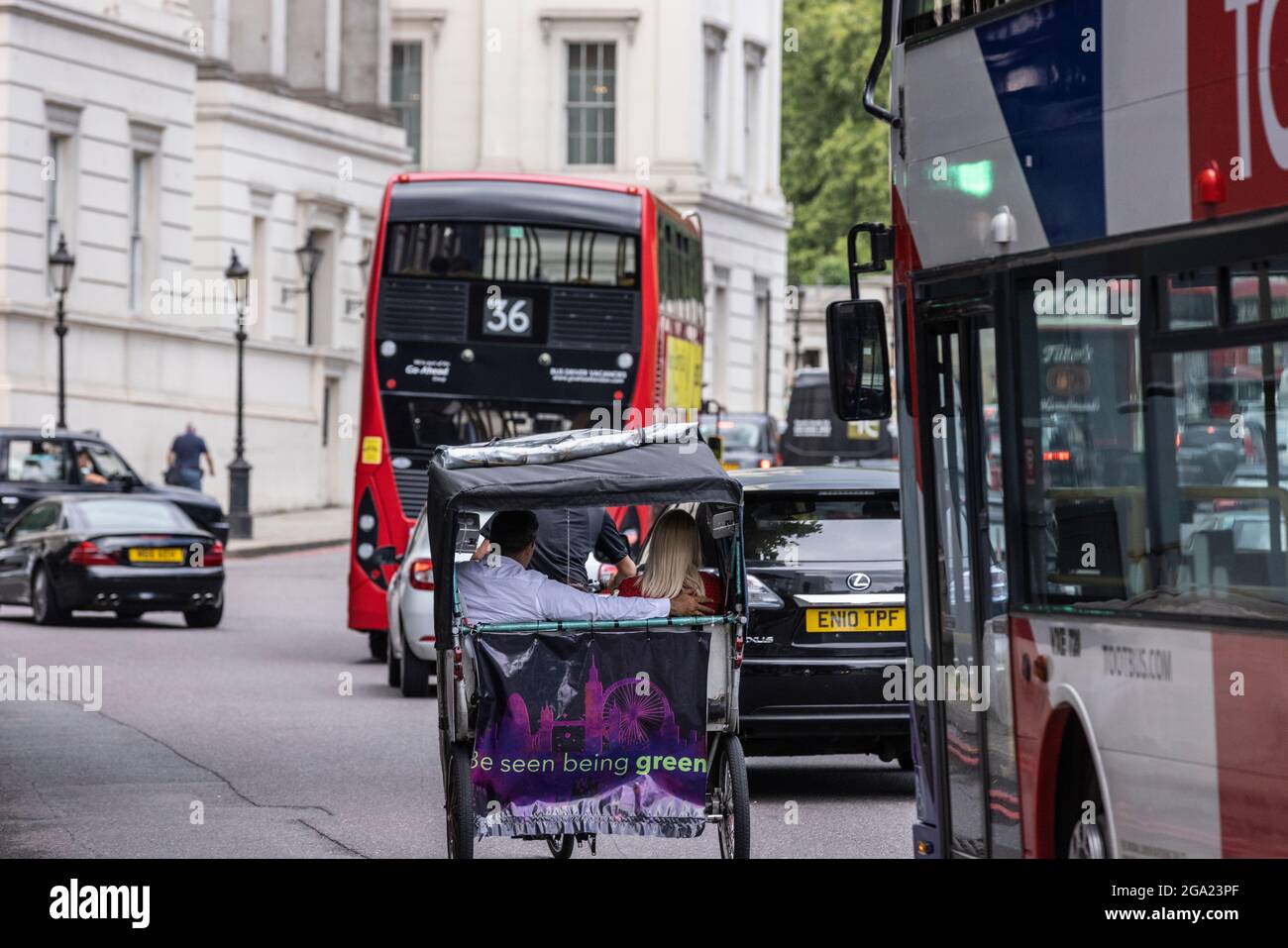 Ein paar Unternehmen eine Fahrt und umgehen den Rush Hour Verkehr in einem Rikscha-Taxi, Hyde Park Corner, London, England, Großbritannien Stockfoto